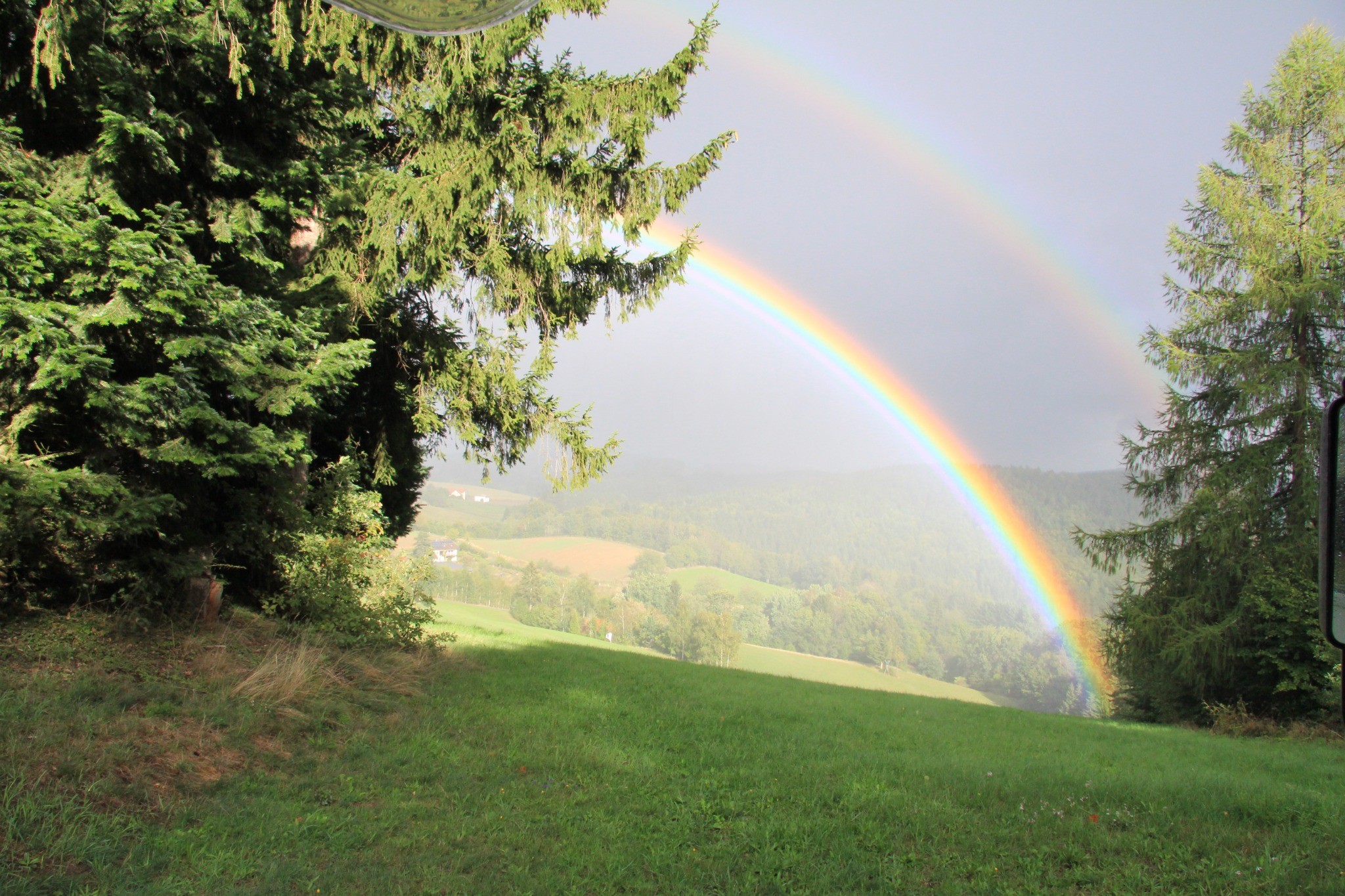 Beratung in der Natur – Sanfte Linie Regenbogen über einer Landschaft